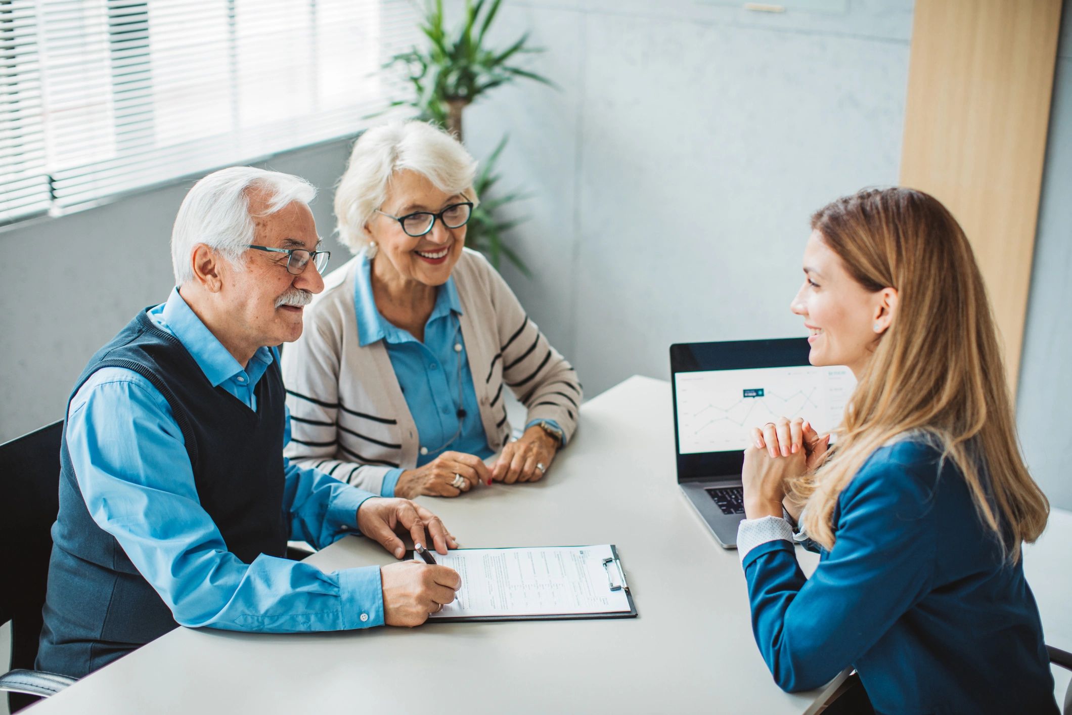 Elderly couple consulting with professional advisor.