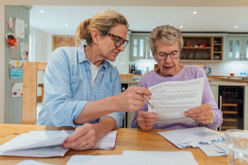 Two women reviewing documents together at a table.