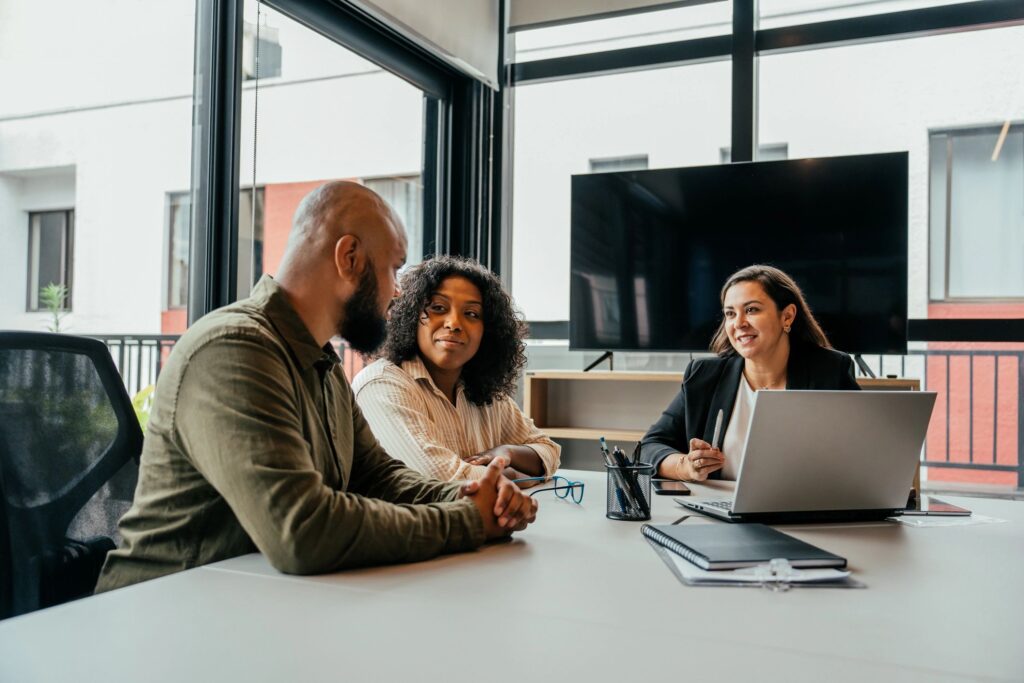 Three professionals having a business discussion in a modern office.